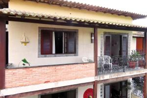 a building with a balcony with a window at Casa Flora in Cabo Frio