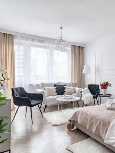ワルシャワにあるGold Premium 2-bedroom Suite 100m from Central Station, modern&high standardの白いリビングルーム(ベッド、椅子付)