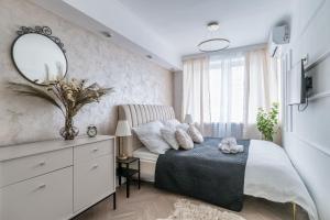 ワルシャワにあるGold Premium 2-bedroom Suite 100m from Central Station, modern&high standardのベッドルーム1室(鏡付きベッド1台、ドレッサー付)