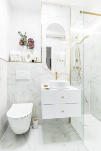 Baño blanco con aseo y lavamanos en Gold Premium 2-bedroom Suite 100m from Central Station, modern&high standard, en Varsovia