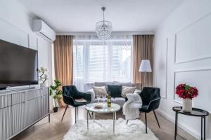 sala de estar con sofá, mesa y sillas en Gold Premium 2-bedroom Suite 100m from Central Station, modern&high standard, en Varsovia