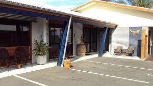 a house with blue columns on a patio at At The Rocks Motorlodge in Napier