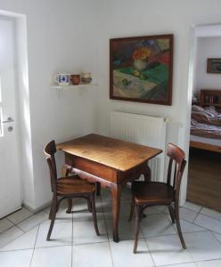a wooden table and two chairs in a room at Ferienhaus alte Försterei in Malchin