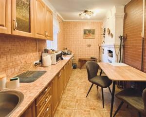 eine Küche mit einem Tisch und einem Waschbecken sowie eine Küche mit einem Tisch in der Unterkunft ПростоРа in Khalepʼye