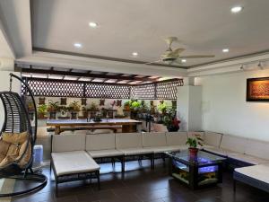 een woonkamer met een bank en een tafel bij Aika Homestay in Shah Alam