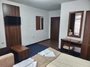 a hotel room with a bed and a desk at Guest House Stoyanov in Bansko