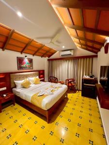 a bedroom with a large bed with a yellow floor at Palcastle Regency in Palakkad
