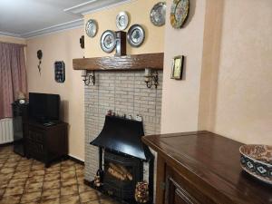 a living room with a fireplace with clocks on the wall at Appartement Parc Forestier 3-4 personnes in Brussels