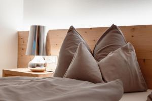 a pile of pillows sitting on top of a bed at ALPINE LOFT Martini in Annaberg im Lammertal