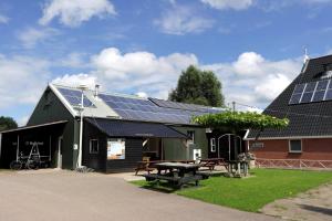 een schuur met zonnepanelen op het dak bij Blokhut camping De Zilveren Maan in De Valom