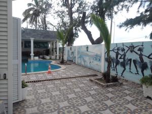 un muro con un murale di giraffe accanto a una piscina di Residencial beira mar Benguela a Benguela
