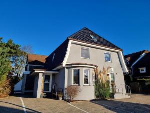 una casa blanca con techo negro en Appartementhaus-Kogge-Wohnung-10 en Cuxhaven