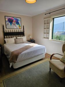 a bedroom with a large bed and a window at Casa Das Videiras in Seixal