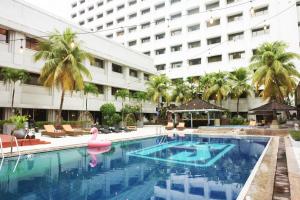 雅加達的住宿－中央商務區薩希德亞大酒店，一座大楼前的游泳池,游泳池内有粉红色的火烈鸟