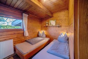 two beds in a log cabin with a window at Bühberg Alm in Blümchen