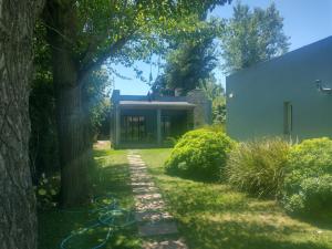 einen Garten mit einem Haus und einem Baum in der Unterkunft Los alamos in Chascomús