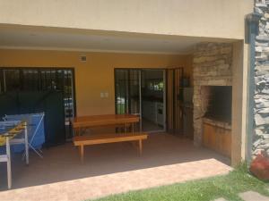 eine Terrasse mit einer Holzbank und einem Kamin in der Unterkunft Los alamos in Chascomús