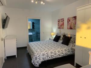 1 dormitorio con 1 cama grande con almohadas negras en Beach Bungalow, en Málaga 15 fotos más