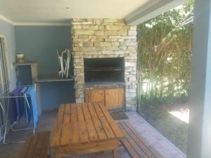 a living room with a stone fireplace and a wooden bench at Los alamos in Chascomús