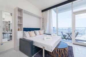 a bedroom with a bed and a large window at Placid Studio close to Dubai Miracle Garden in Dubai
