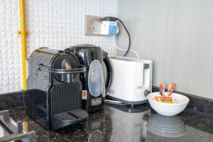 a kitchen counter with a coffee maker and a toaster at Placid Studio close to Dubai Miracle Garden in Dubai
