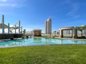 una gran piscina en medio de un parque en Placid Studio close to Dubai Miracle Garden en Dubái