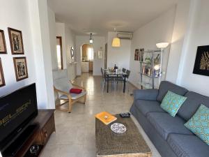 - un salon avec un canapé bleu et une table dans l'établissement Nerja Paradise Rentals - Apt Chimenea A1E, à Nerja