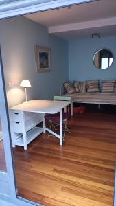 Habitación con escritorio blanco y sofá. en Apartamento en Pontevedra con terraza y garaje en Poio