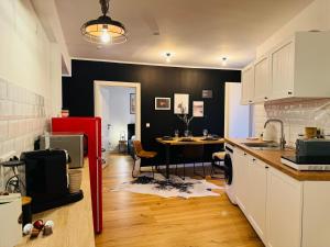 Il comprend une cuisine équipée d'un réfrigérateur rouge et d'une table. dans l'établissement Klassen Stay - Designer Apartment für 6 - Zentral - 2x Kingsize, à Essen