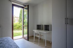 1 dormitorio con escritorio, TV y ventana en The Pellegrino Spot, en Numana
