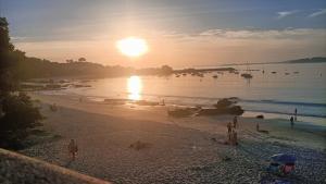 un gruppo di persone su una spiaggia al tramonto di Apartamento en Pontevedra con terraza y garaje a Poio