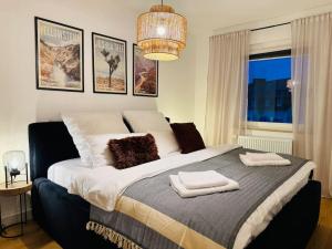 1 dormitorio con 1 cama grande y toallas. en Klassen Stay - Designer Apartment für 6 - Zentral - 2x Kingsize, en Essen