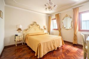 sypialnia z łóżkiem, stołem i lustrem w obiekcie Locanda Al Leon w Wenecji