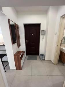 een hal met een zwarte deur en een tegelvloer bij Goldensun Apartment in Boedapest