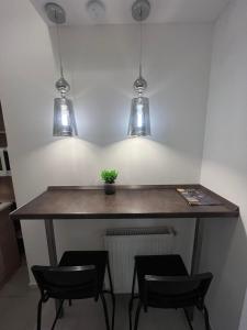 a table in a room with two chairs and three lights at Goldensun Apartment in Budapest