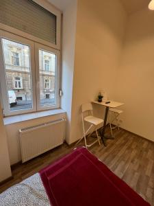 een kleine kamer met een tafel en een raam bij Goldensun Apartment in Boedapest