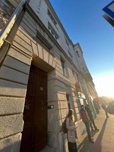 een groep mensen die buiten een gebouw staan bij Goldensun Apartment in Boedapest