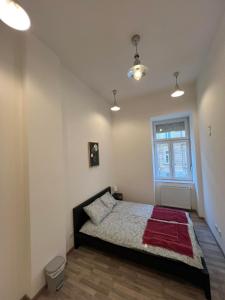 a bedroom with a bed with a red blanket on it at Goldensun Apartment in Budapest