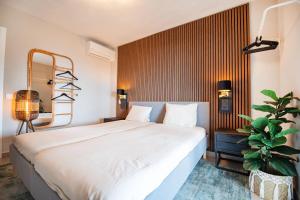 Un dormitorio con una gran cama blanca y una planta en Calpeview II Luxury Villa By Calpitality en Calpe