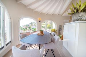 a dining room with a blue table and white chairs at Calpeview II Luxury Villa By Calpitality in Calpe