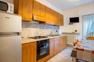 a kitchen with wooden cabinets and a stove at Appartamento Piazzi 2 in Caderzone