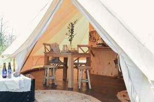 a tent with a table and chairs in it at Smuk Grutte Bell Tent nabij het water in Friesland in Echtenerbrug +38 photos