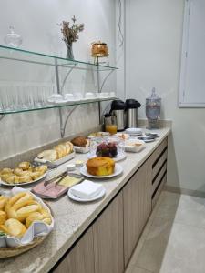 um buffet com muitos tipos diferentes de pão e pastelaria em Nathus Hotel em Chapadão do Sul