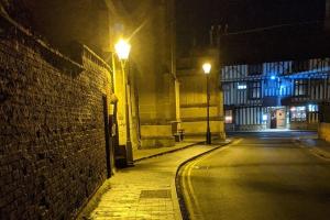 una calle de ciudad vacía por la noche con luces de calle en Oakleigh house en Stratford-upon-Avon