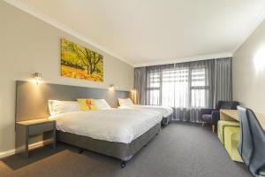um quarto de hotel com duas camas e uma janela em Cowra Services Club Motel em Cowra