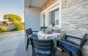 - une table et des chaises sur la terrasse couverte arrière d'une maison dans l'établissement 1 Bedroom Cozy Apartment In Valbandon, à Valbandon