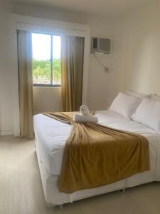 a bedroom with a large bed with a window at MODERNO FLAT LAKE SIDE in Brasília