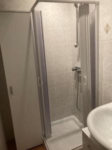 um chuveiro com uma porta de vidro ao lado de um lavatório em Residenza “Al Belvedere” em Tolve