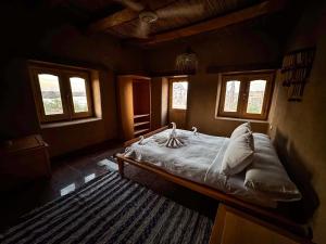 - une chambre avec un lit dans une pièce dotée de fenêtres dans l'établissement Eco Nubia, à Assouan
