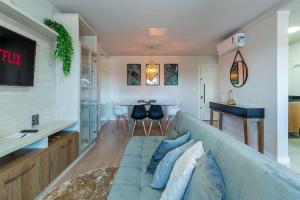 sala de estar con sofá azul y mesa en Campos de Canela 402 - Stay House Temporada, en Canela